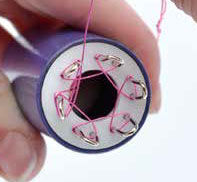 Wire being wrapped around the spokes of the knitter
